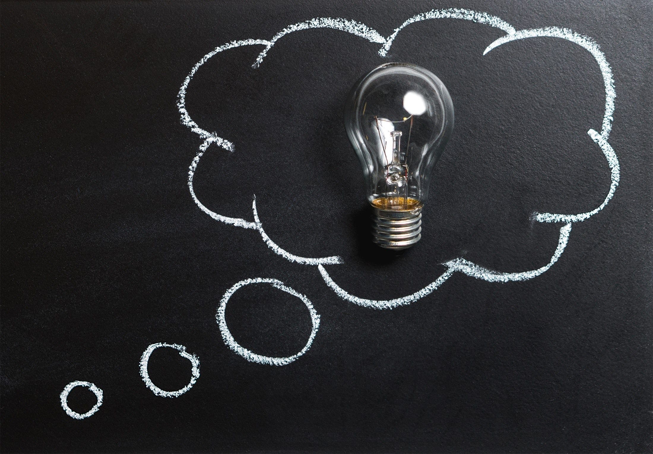 A lightbulb in a chalk cloud on a blackboard