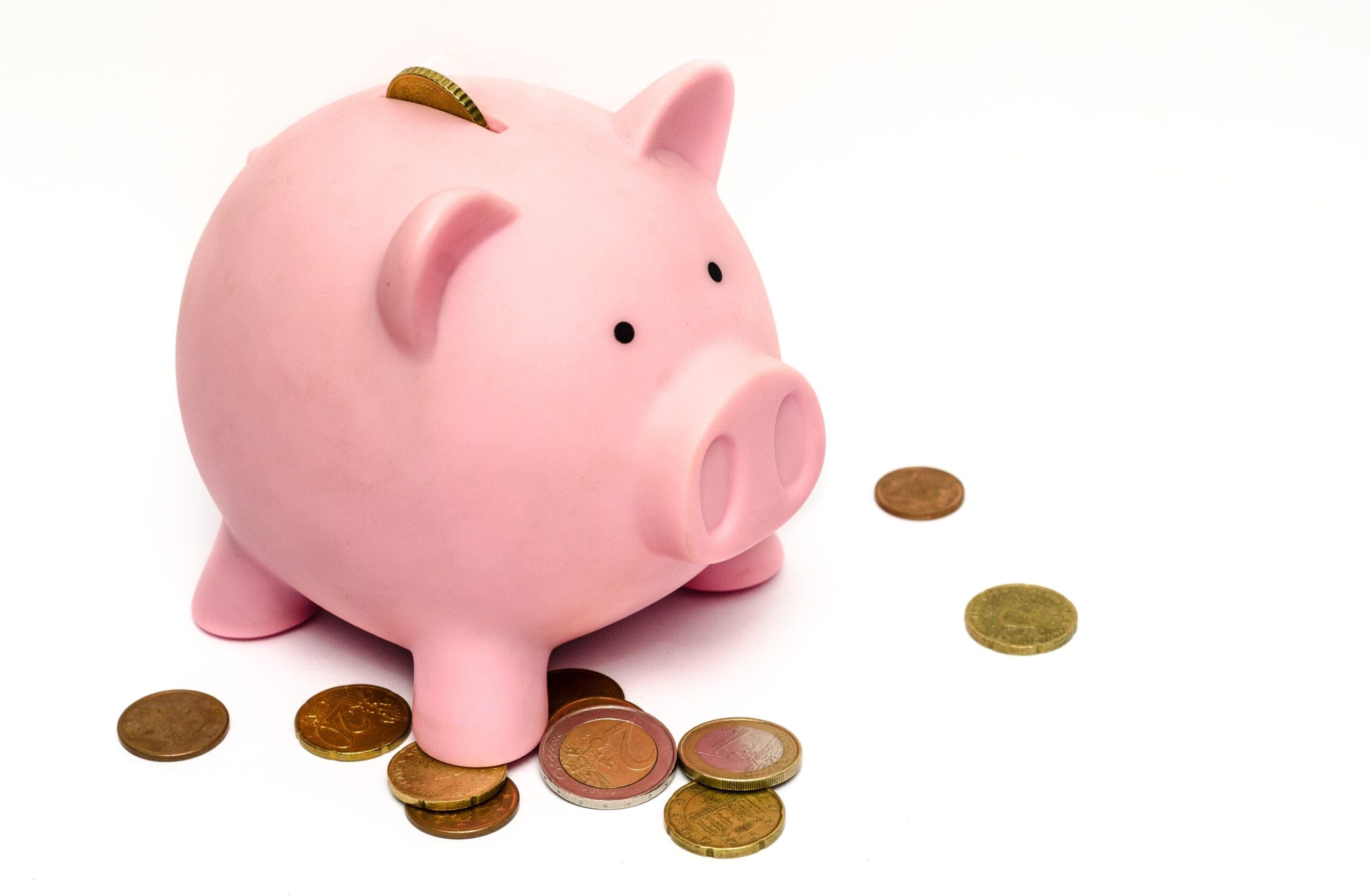 Coins lay around a piggy bank